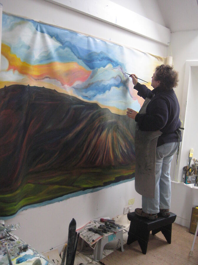 Jeanne at work at her monumental 45 x 6 ft panorama of Hoy. Smaller versions are available in the shop.